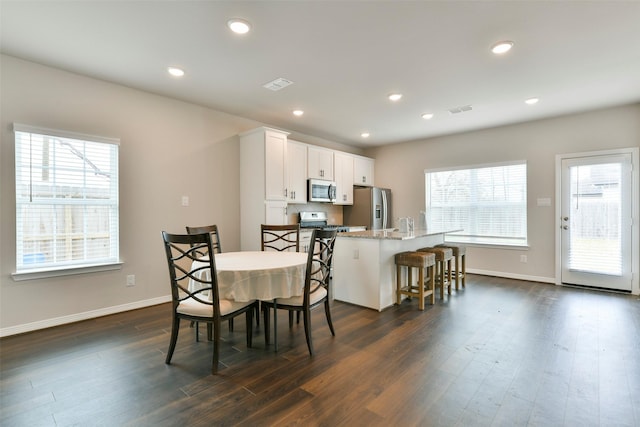 dining area with plenty of natural light and dark hardwood / wood-style flooring