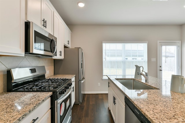 kitchen with appliances with stainless steel finishes, white cabinets, and sink