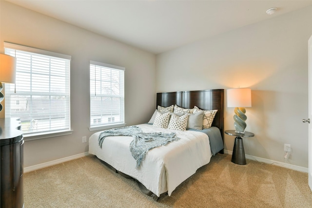 bedroom featuring light colored carpet and multiple windows