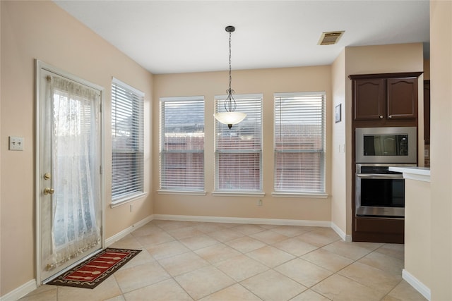 unfurnished dining area with light tile patterned flooring