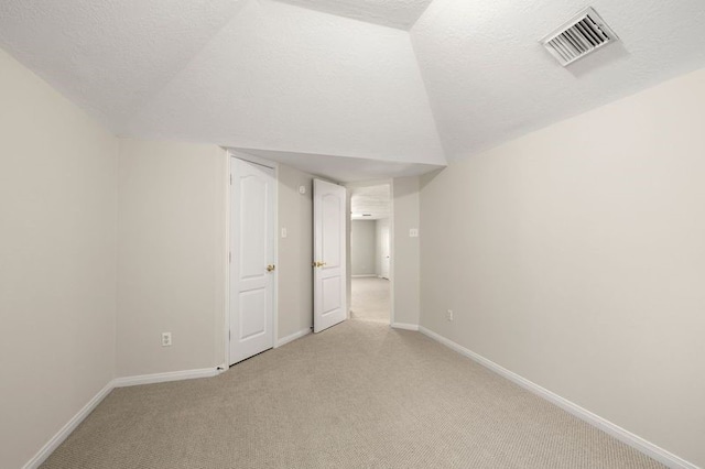 interior space with vaulted ceiling and a textured ceiling