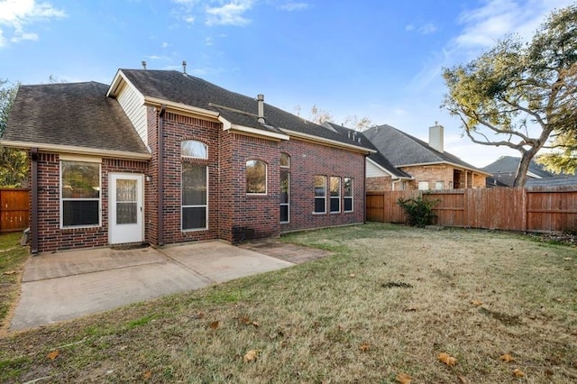 rear view of property featuring a yard and a patio area