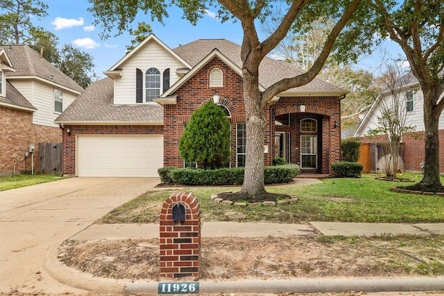 view of property featuring a garage and a front lawn