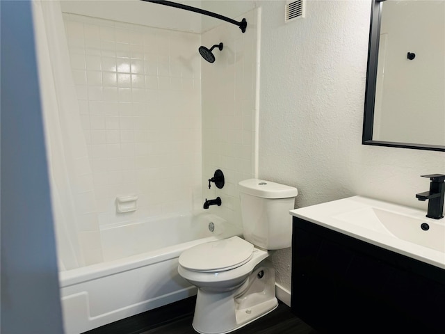 full bathroom featuring toilet, tiled shower / bath, and vanity