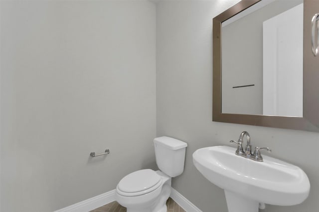 16163 Sheridan River Trl, Conroe, TX 77302 - bathroom featuring toilet, a sink, and baseboards