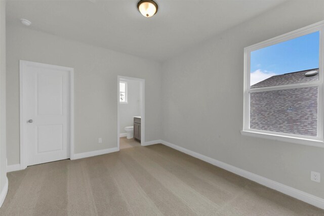 16163 Sheridan River Trl, Conroe, TX 77302 - unfurnished bedroom with light carpet, baseboards, and connected bathroom