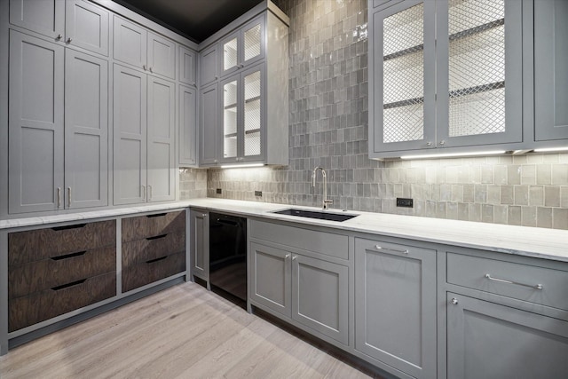 kitchen featuring sink, dishwasher, and gray cabinets