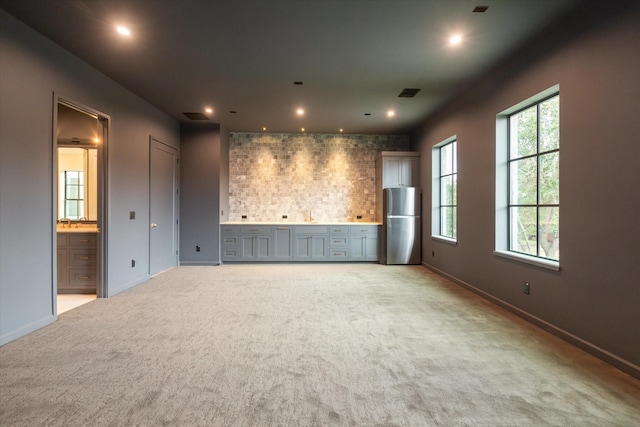 unfurnished living room with light colored carpet