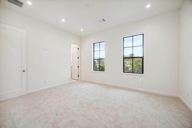 spare room featuring light colored carpet