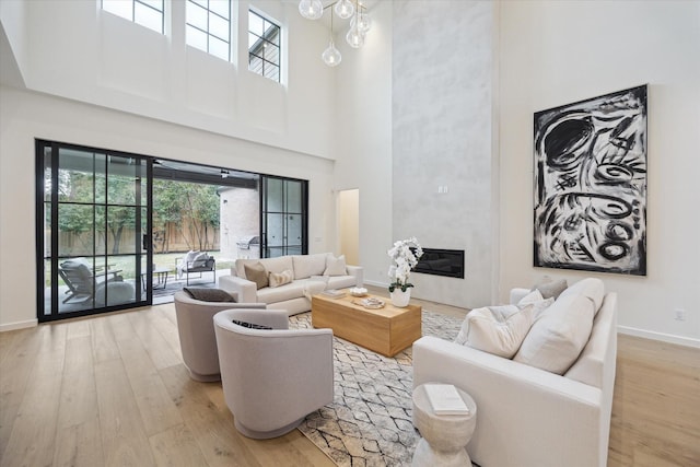 living room featuring a towering ceiling and light hardwood / wood-style flooring