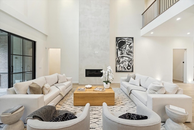 living room featuring a towering ceiling and light wood-type flooring