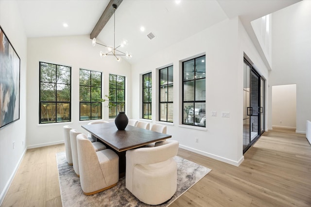 dining space featuring vaulted ceiling with beams, a chandelier, and light hardwood / wood-style floors