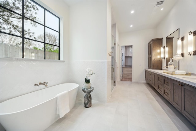 bathroom featuring shower with separate bathtub, tile patterned floors, and vanity