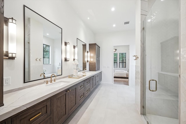 bathroom with a shower with shower door, vanity, tile patterned flooring, and plenty of natural light