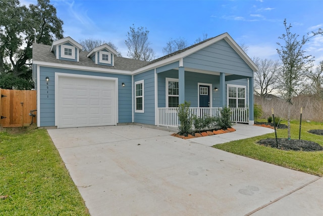 view of front of property featuring covered porch, a front lawn, and a garage