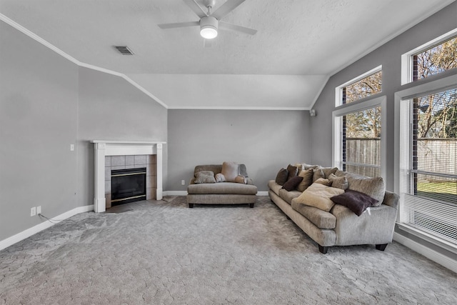 living room with a fireplace, vaulted ceiling, plenty of natural light, and carpet