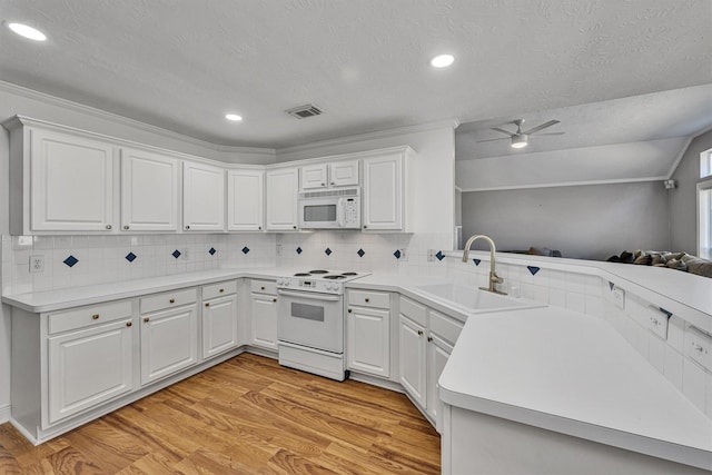 kitchen with sink, white cabinets, white appliances, and light hardwood / wood-style floors