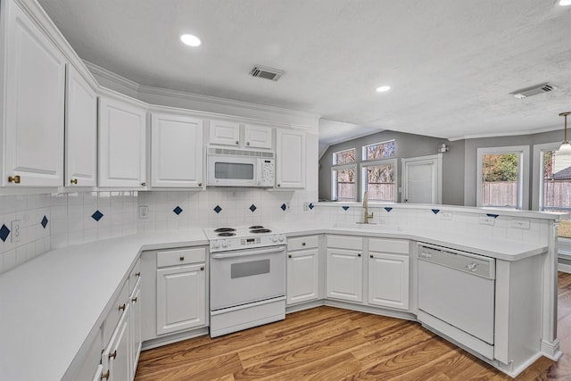 kitchen with white cabinetry, sink, and white appliances