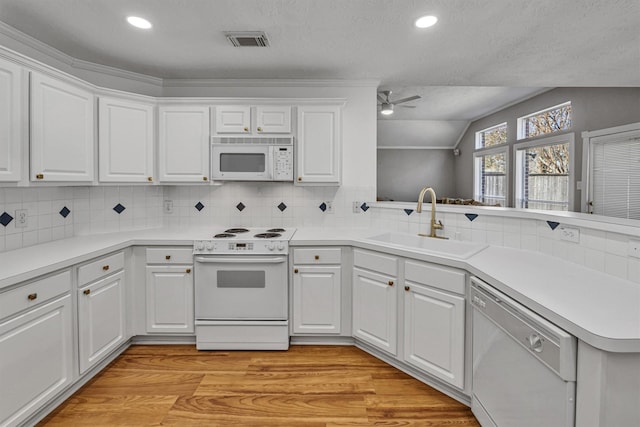 kitchen featuring white cabinetry, sink, white appliances, kitchen peninsula, and a textured ceiling