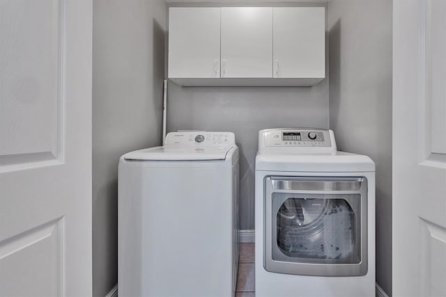 laundry room with cabinets and washer and clothes dryer