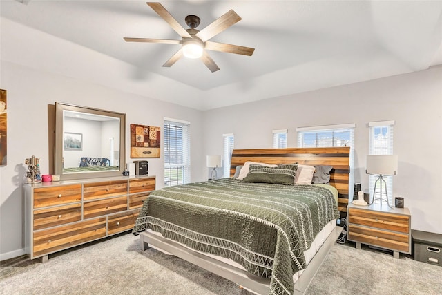 bedroom with ceiling fan, light colored carpet, and multiple windows