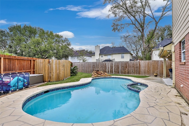 view of pool with a patio area and an in ground hot tub