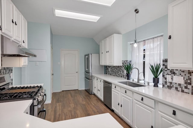 kitchen featuring pendant lighting, appliances with stainless steel finishes, white cabinetry, sink, and backsplash