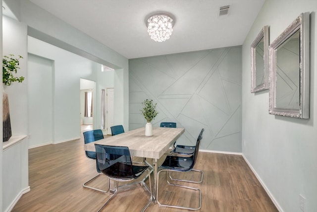 dining space featuring dark hardwood / wood-style flooring and a chandelier