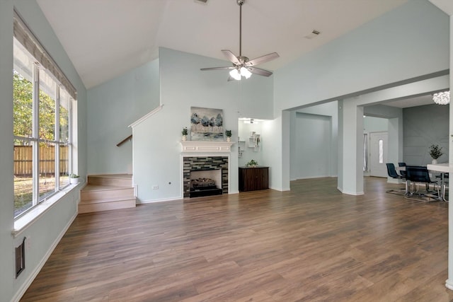 unfurnished living room featuring ceiling fan, wood-type flooring, a stone fireplace, and high vaulted ceiling