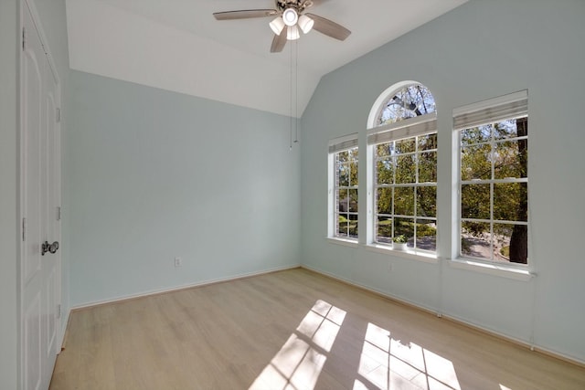 empty room with light wood-type flooring, ceiling fan, and lofted ceiling