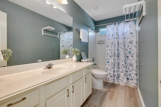 full bathroom featuring hardwood / wood-style flooring, toilet, vanity, and shower / tub combo with curtain