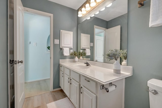 bathroom featuring toilet, hardwood / wood-style flooring, and vanity