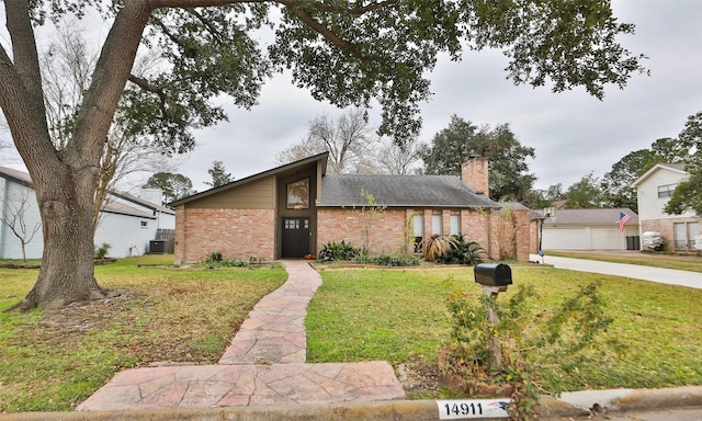 view of front of house with a front lawn and cooling unit