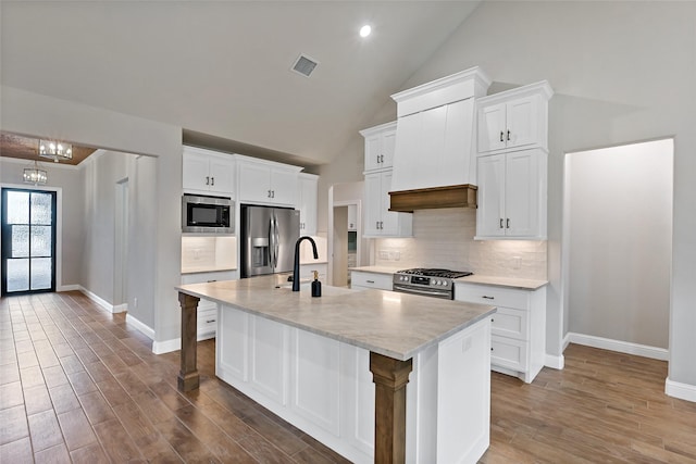 kitchen featuring sink, white cabinetry, an island with sink, stainless steel appliances, and high vaulted ceiling