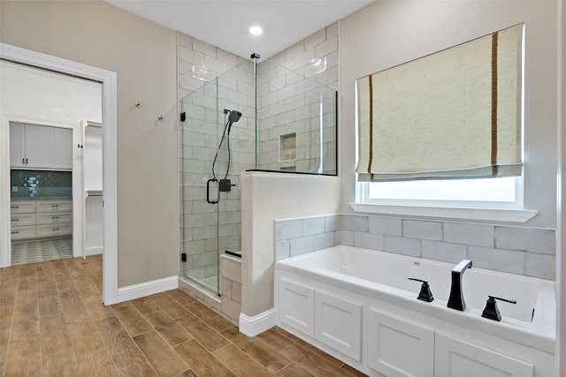 bathroom with backsplash and shower with separate bathtub