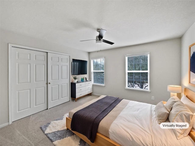 bedroom with ceiling fan, a closet, and light carpet