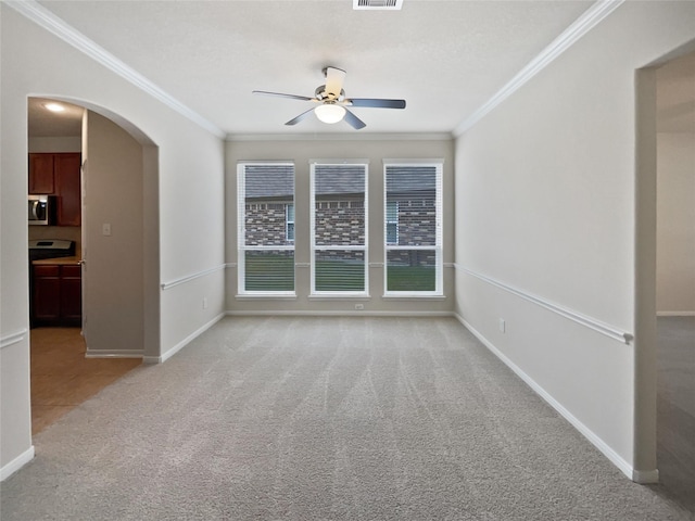 carpeted empty room featuring ceiling fan and ornamental molding