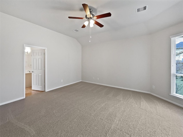 unfurnished room with ceiling fan, light colored carpet, and vaulted ceiling