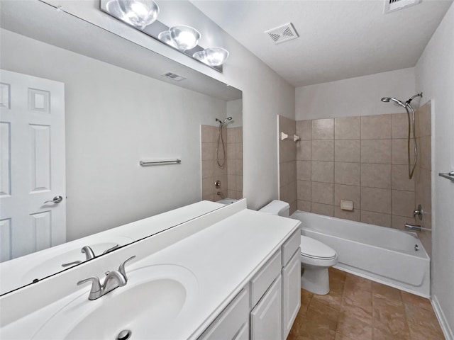 full bathroom featuring toilet, tiled shower / bath combo, tile patterned floors, and vanity