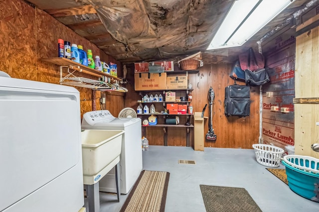 interior space with washing machine and clothes dryer and wooden walls