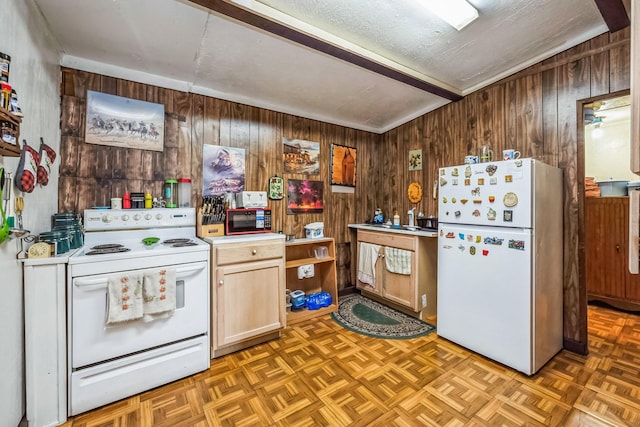 kitchen featuring wood walls, parquet floors, and white appliances