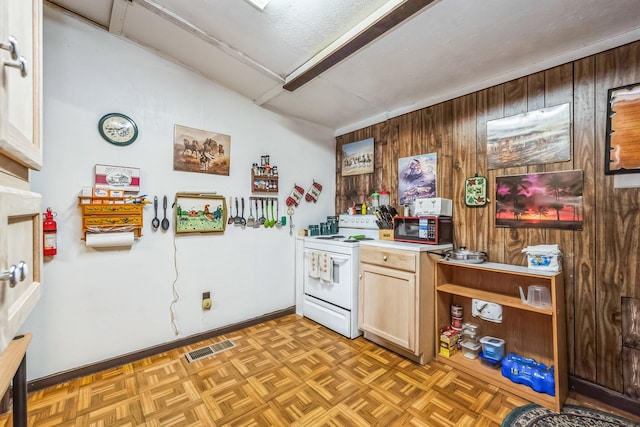 kitchen featuring light parquet floors, wooden walls, and electric stove