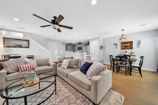 living room featuring ceiling fan and light hardwood / wood-style floors