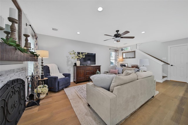 living room featuring ceiling fan and light hardwood / wood-style flooring