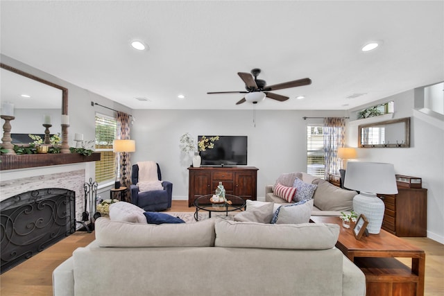 living room featuring light hardwood / wood-style floors and ceiling fan