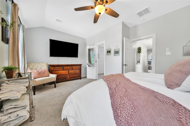 bedroom with ceiling fan, light colored carpet, ensuite bath, and lofted ceiling