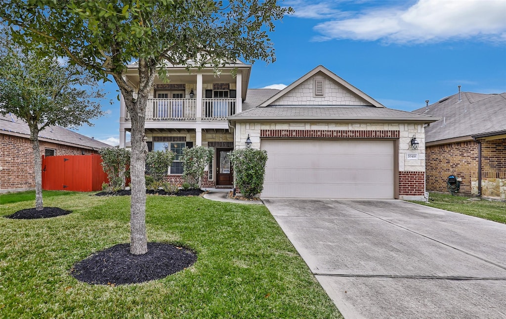 view of front of home featuring a front lawn, a garage, and a balcony