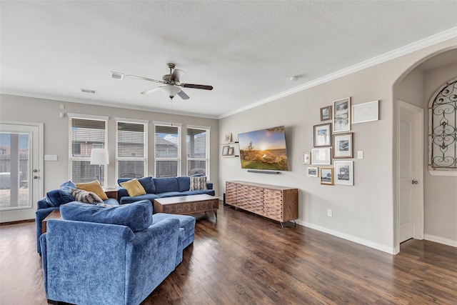 living room with a textured ceiling, dark hardwood / wood-style floors, ornamental molding, and plenty of natural light