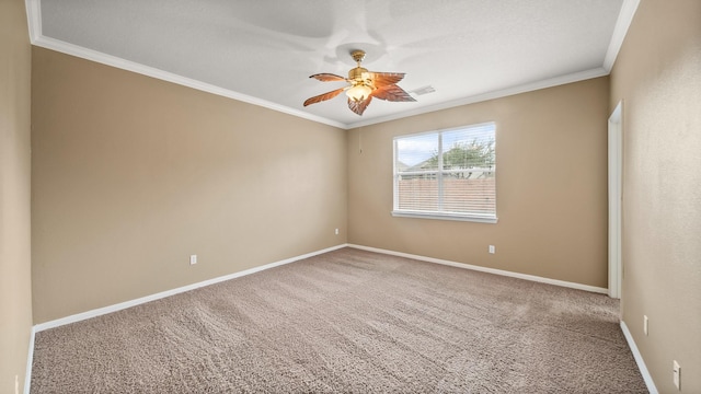 empty room featuring ceiling fan, crown molding, and carpet flooring