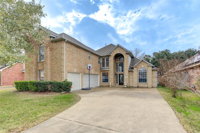 traditional-style home featuring an attached garage, a front lawn, concrete driveway, and brick siding